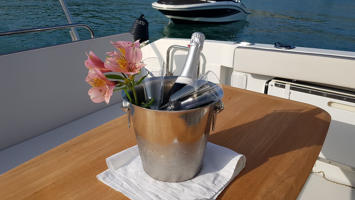 Luxury champagne bottle served on elegant boat table with sea backdrop for celebration